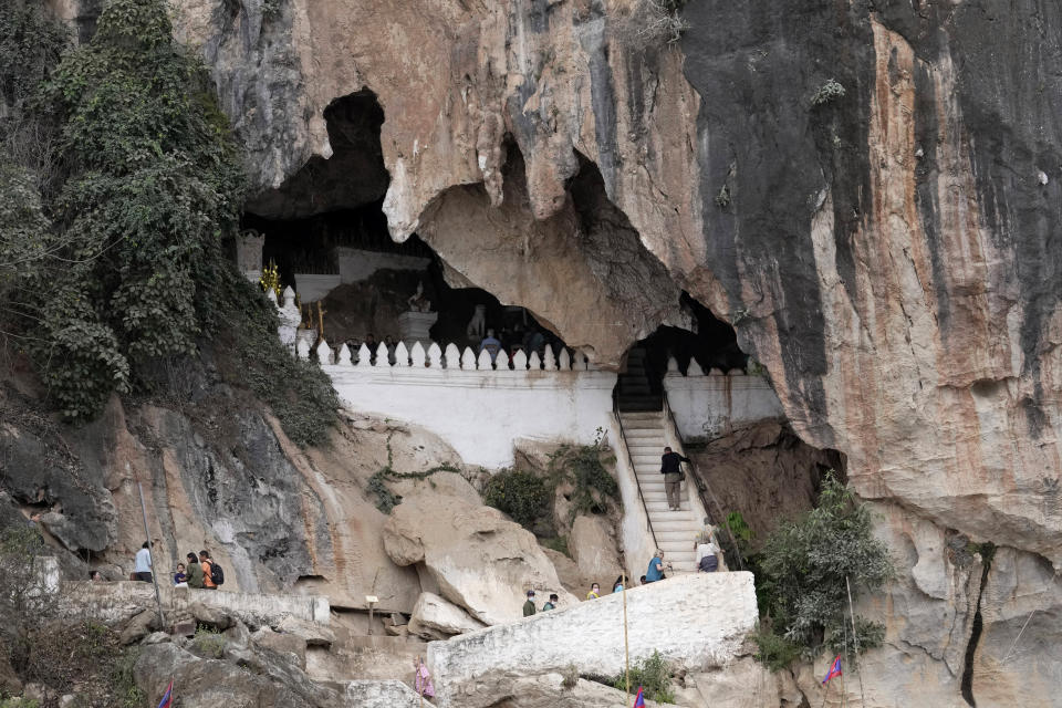 Tourists visit Oak Ou cave located near Mekong river in Luang Prabang, Laos, Sunday, Jan. 28, 2024. Luang Prabang was named a UNESCO World Heritage Site nearly 30 years ago, but a multibillion-dollar dam project is raising questions that could deprive the city of its coveted status and prompting broader concerns the Mekong River could be ruined by multiple dams that are being planned. (AP Photo/Sakchai Lalit)