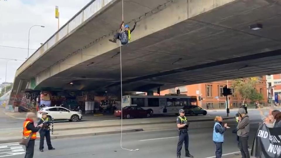 The protester, identified as 69-year-old Meme Thorne, abseiled off Morphett Street, disrupting North Terrace commuters. Picture: Facebook