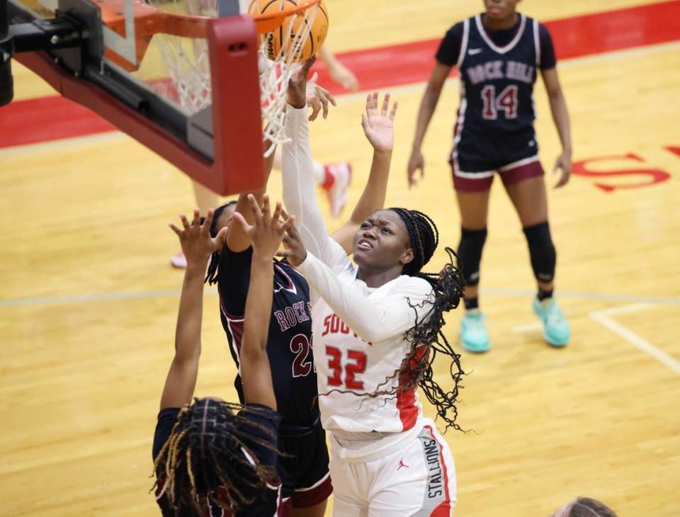 South Pointe’s JaNyia Cunningham (32) puts up the shot against Rock Hill’s Aubrey Stevenson, left, and Sarah Anderson-Wildly, middle.