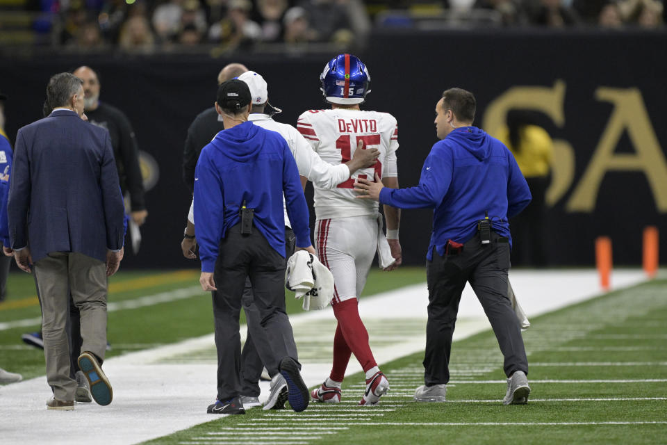 New York Giants quarterback Tommy DeVito (15) is helped off the field after being hit during the first half of an NFL football game against the New Orleans Saints , Dec. 17, 2023, in New Orleans. (AP Photo/Matthew Hinton)