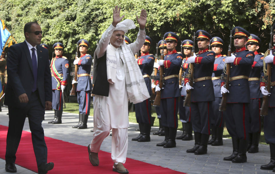 Afghanistan's President Ashraf Ghani, center, greets as he arrives to offer Eid al-Adha prayers at the presidential palace in Kabul, Afghanistan, Sunday, Aug. 11, 2019. Ghani is urging the nation to determine its fate without foreign interference as the United States and the Taliban appear to near a peace deal without the Afghan government at the table.(AP Photo/Nishanuddin Khan)