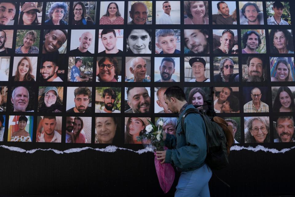 A man walks past a billboard calling for the return of about 240 hostages who were abducted during the Oct. 7, Hamas attack on Israel. in Jerusalem on Friday, Nov. 24, 2023. Friday marks the start of a four-day cease-fire in the Israel-Hamas war, during which the Gaza militants pledged to release 50 hostages in exchange for 150 Palestinians imprisoned by Israel.