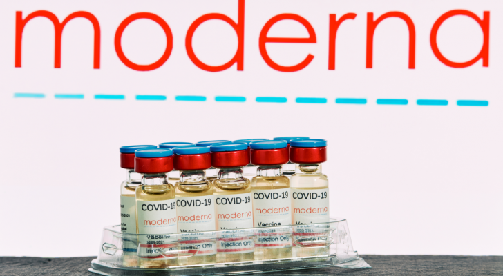 Moderna (MRNA) research Coronavirus (Covid 19) vaccine. Row of vaccine bottles with blurred Moderna company logo on background.