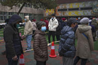 Residents wearing face masks to protect from the coronavirus line up for the coronavirus testing at a school in Fengtai District in Beijing, Monday, Jan. 24, 2022. Chinese authorities have lifted a monthlong lockdown of Xi'an and its 13 million residents as infections subside ahead of the Winter Olympics. Meanwhile, the 2 million residents of one Beijing district are being tested following a series of cases in the capital. (AP Photo/Andy Wong)