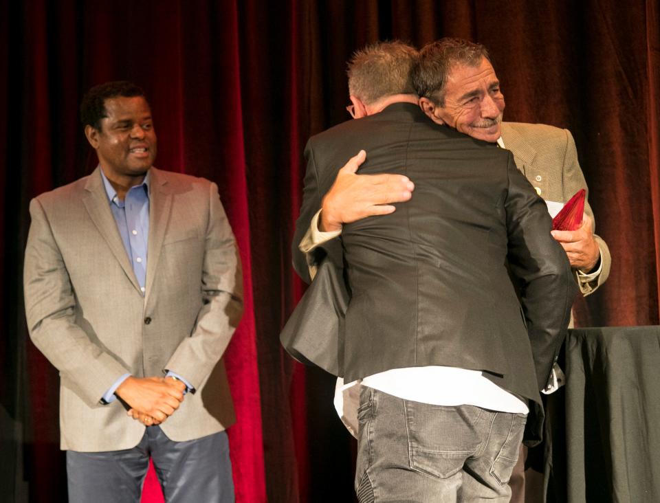 Elmer Tabor, right, hugs Dennis Gingerich, center, after Gingerich won the 2018 Elmer Tabor Generosity Award at the Excellence in Nonprofit Performance Yearly Awards. Gingerich will present the award this year.