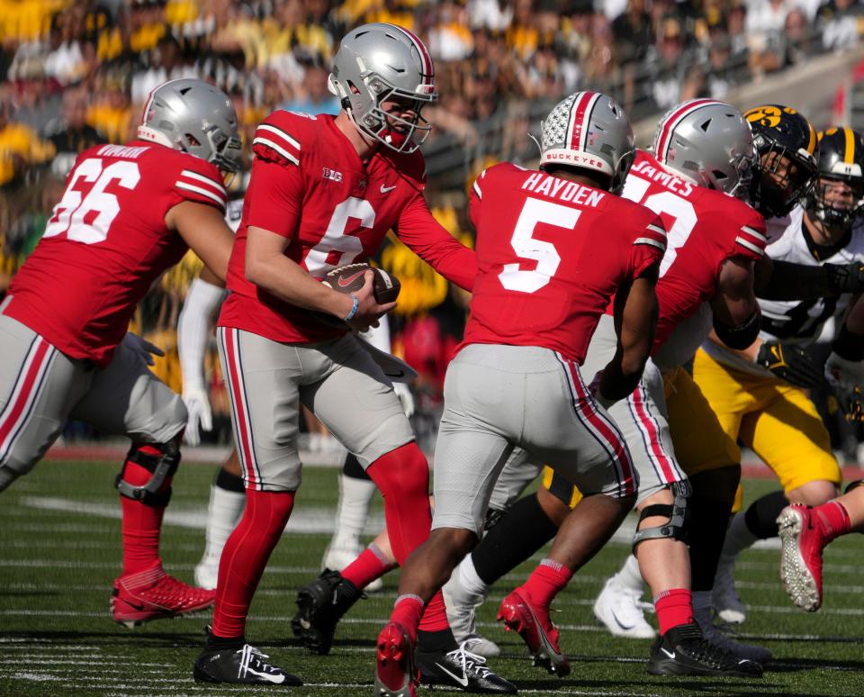 Ohio State quarterback Kyle McCord fakes a handoff to running back Dallan Hayden.