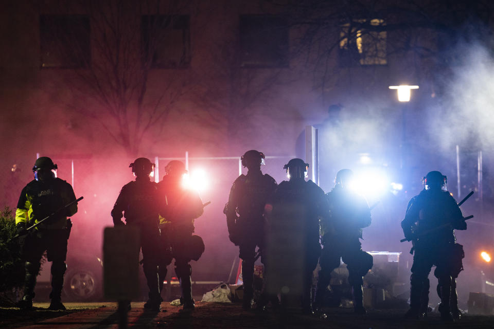 Law enforcement officers clear an area of demonstrators during a protest over Sunday's fatal shooting of Daunte Wright during a traffic stop, outside the Brooklyn Center Police Department on Wednesday, April 14, 2021, in Brooklyn Center, Minn. (AP Photo/John Minchillo)