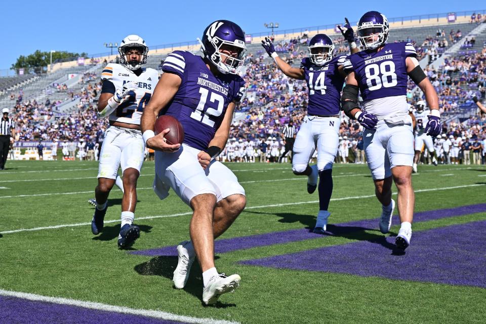 Sep 9, 2023; Evanston, Illinois, USA; Northwestern Wildcats quarterback Jack Lausch (12) celebrates after scoring a touchdown in the first half against the University of Texas El Paso Miners at Ryan Field. Mandatory Credit: Jamie Sabau-USA TODAY Sports