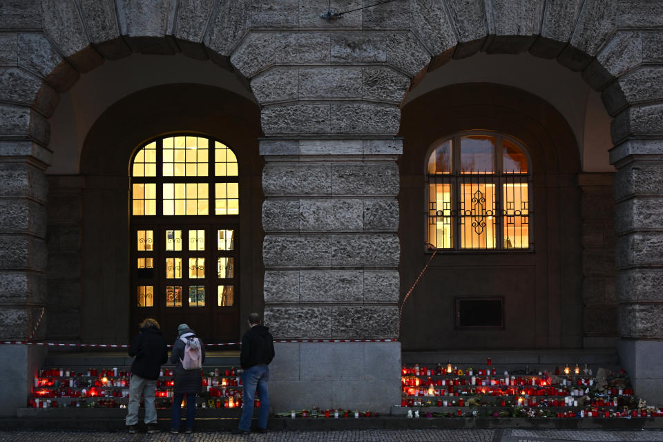 Mourners bring flowers and candles placing them outside the building of Philosophical Faculty of Charles University in downtown Prague, Czech Republic, Saturday, Dec. 23, 2023. A lone gunman opened fire at a university on Thursday, killing more than a dozen people and injuring dozens. (AP Photo/Denes Erdos)