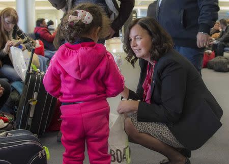 Canada's ambassador to Lebanon, Michelle Cameron, offers a teddy bear to a Syrian child at the beginning of an airlift of Syrian refugees to Canada, at the Beirut International airport December 10, 2015 in a photo provided by the Canadian military. REUTERS/Corporal Darcy Lefebvre/Canadian Forces Combat Camera/Handout via Reuters