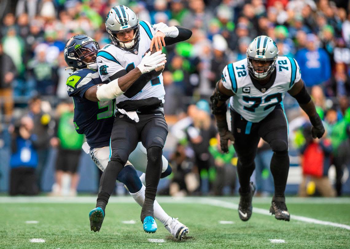 Seattle Seahawks defensive end Darrell Taylor (52) sacks Carolina Panthers quarterback Sam Darnold (14) in the second quarter of an NFL game at Lumen Field in Seattle Wash., on Dec. 11, 2022.