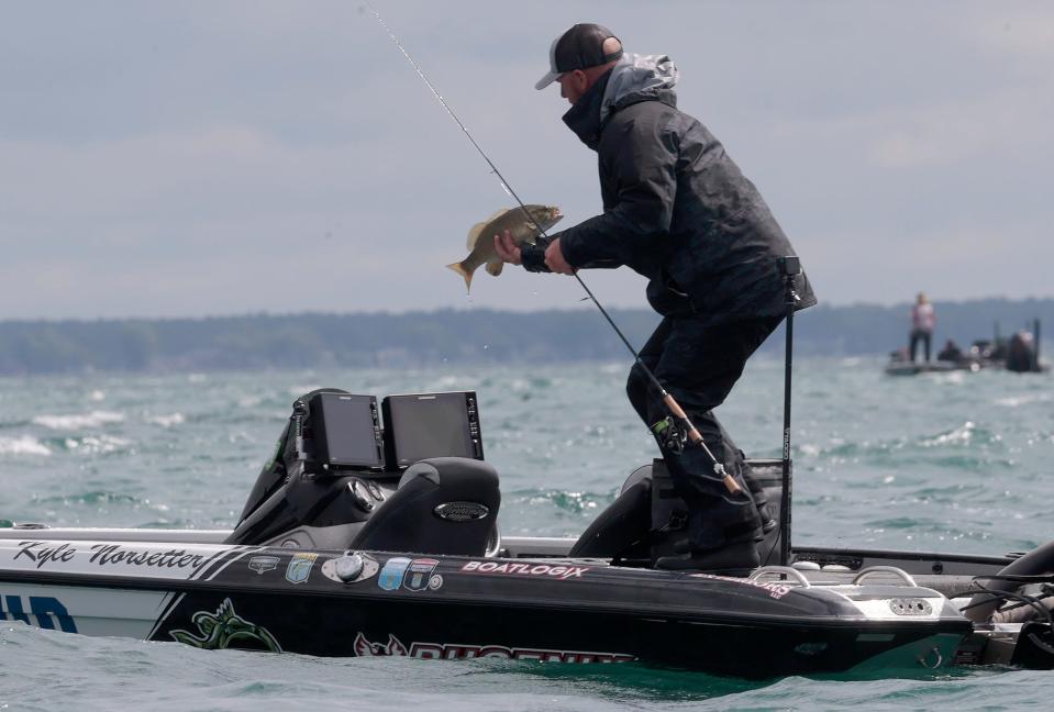 Kyle Norsetter looks over a smallmouth bass before deciding to put it back into the lake during the Bassmaster Elite Series competition in Anchor Bay on Lake St. Clair on Saturday, July 29, 2023.