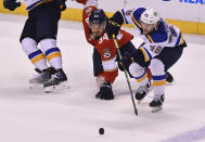 Florida Panthers left wing Ryan Lomberg (94) battles for possession with St. Louis Blues defenseman Scott Perunovich (48) during the second period of an NHL hockey game Saturday, Dec. 4, 2021, in Sunrise, Fla. (AP Photo/Jim Rassol)