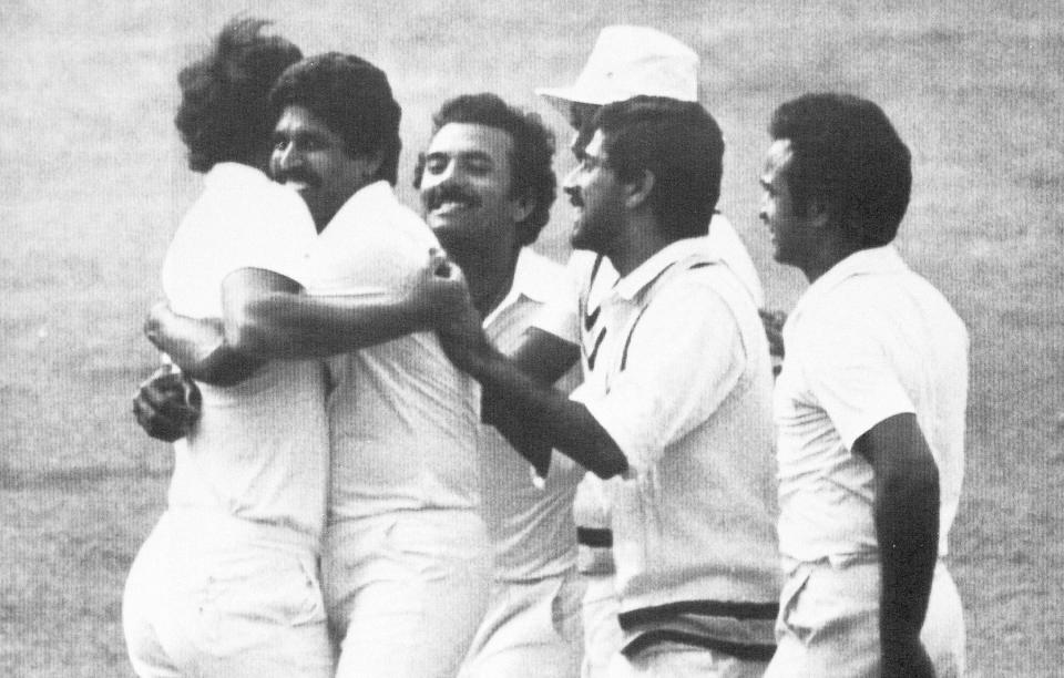 FILE - Indian cricket team captain Kapil Dev, second from left, hugs Indian bowler Madan Lal while the rest of the Indian team celebrate at Lord's after Gavaskar had caught West Indian, Larry Gomes, for five of the bowling of Madan Lal during the Prudential World Cup Final in London, June 25, 1983. India won the World Cup for the first time in 1983. (AP Photo/Peter Kemp, File)