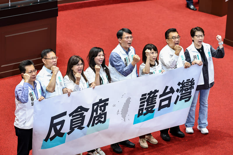 立法院21日表決行政院對國會改革修法所提覆議案，台灣民眾黨立法院黨團振臂高喊「反貪腐 護台灣」。（中央社）