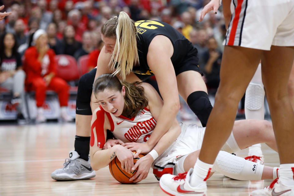 Ohio State guard Taylor Mikesell, bottom, fights for the ball with Iowa forward Monika Czinano during the first half of an NCAA college basketball game at Value City Arena in Columbus, Ohio, Monday, Jan. 23, 2023. (AP Photo/Joe Maiorana)