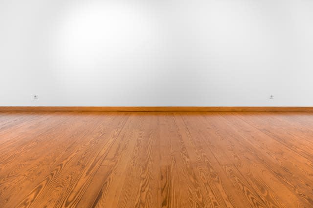 Empty white wall with spot lights and wooden floor