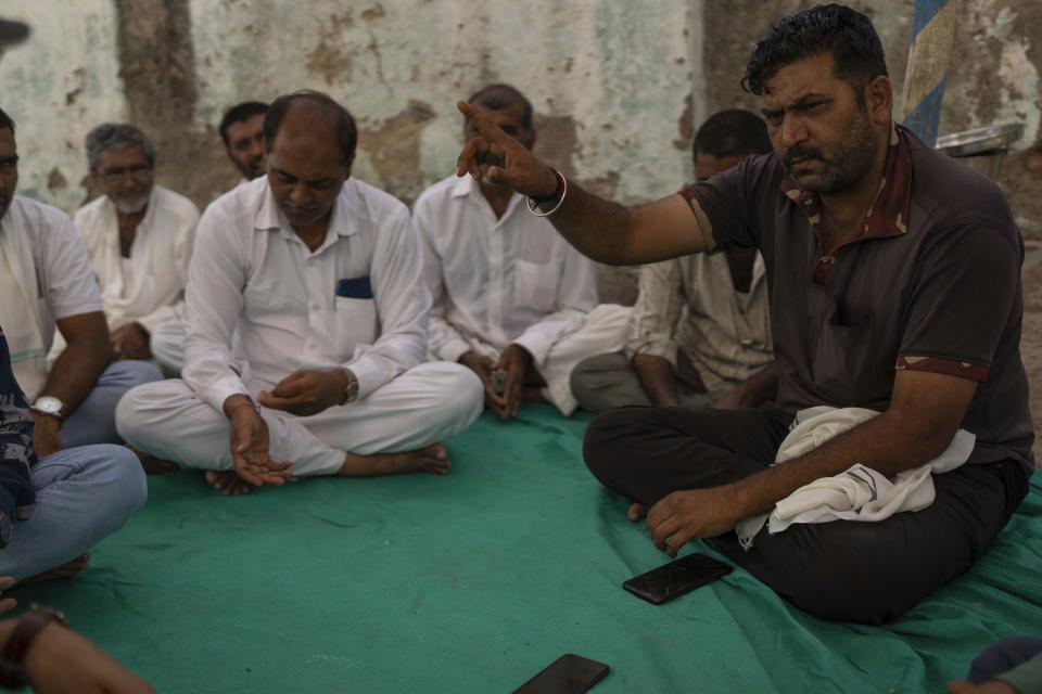 Raydhan Bhai, right, whose two nephews drowned in a bridge that collapsed on Sunday, speaks with the Associated Press outside their house in Morbi town of western state Gujarat, India, Tuesday, Nov. 1, 2022. “We are devastated,” Bhai said. His nephews Yash Devadana, 12, and Raj Bhagwanji Bhai,13, were cousins living in the same house. They were good friends too, their family said, always seen playing together in the neighborhood. The two also loved swimming and often went to the Machchu river to cool themselves off. (AP Photo/Rafiq Maqbool)