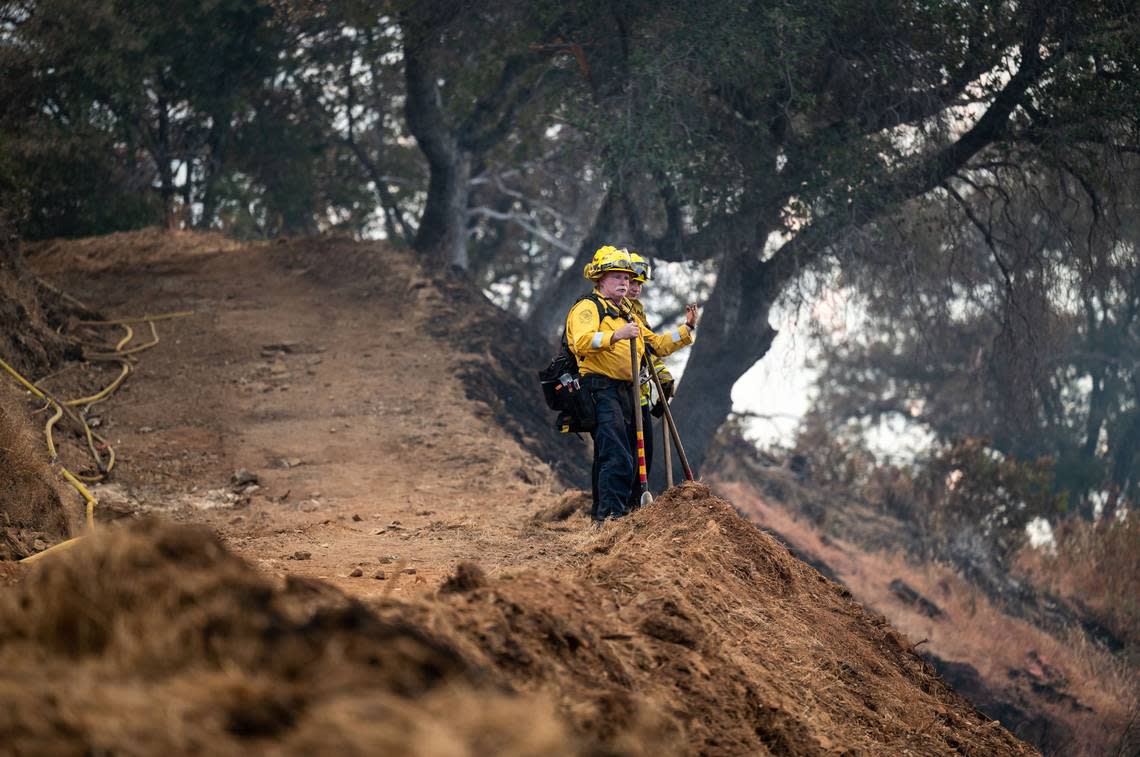 Cal Fire personnel strategize to contain the Electra Fire in a gully between Clinton Bar Road and the North Fork Mokelumne River in Amador County on Wednesday, July 6, 2022.