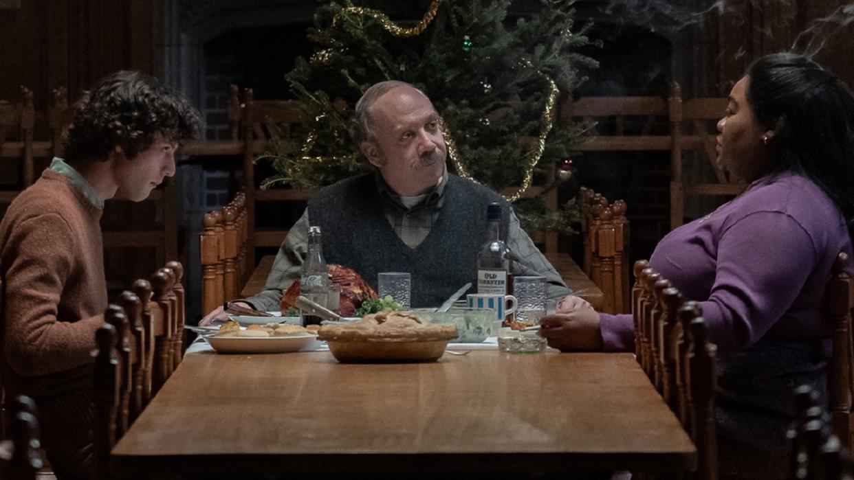  Dominic Sessa, Paul Giamatti and Da'Vine Joy Randolp sitting around the dinner table at Christmas in The Holdovers. 