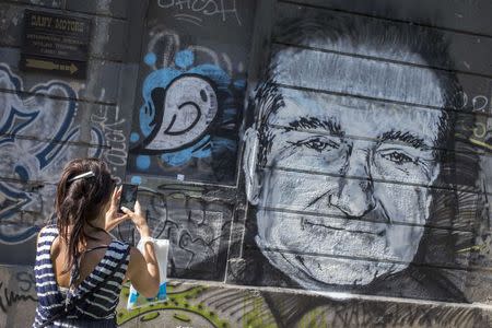 A woman takes a picture of a mural depicting late actor Robin Williams in Belgrade, August 13, 2014. REUTERS/Marko Djurica