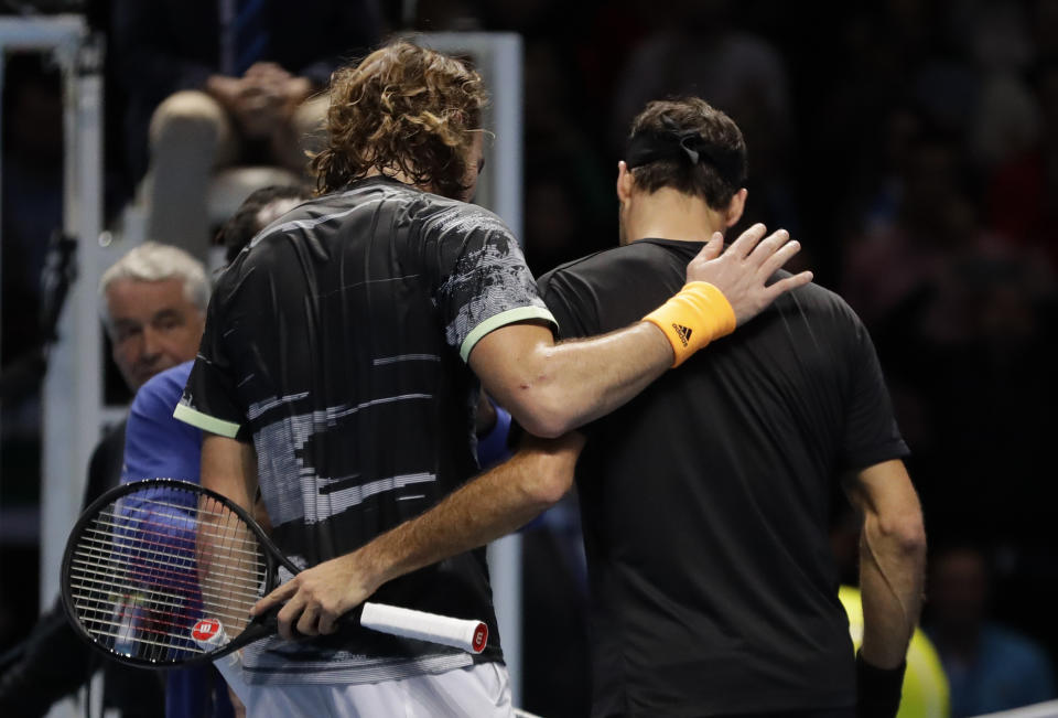 Stefanos Tsitsipas of Greece puts his arm around Roger Federer of Switzerland after winning match point during their ATP World Tour Finals semifinal tennis match at the O2 Arena in London, Saturday, Nov. 16, 2019. (AP Photo/Kirsty Wigglesworth)