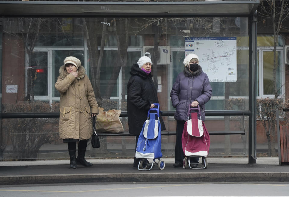 Women wait a bus at a bus stop in Almaty, Kazakhstan, Monday, Jan. 10, 2022. Kazakhstan's health ministry says over 150 people have been killed in protests that have rocked the country over the past week. President Kassym-Jomart Tokayev's office said Sunday that order has stabilized in the country and that authorities have regained control of administrative buildings that were occupied by protesters, some of which were set on fire. (Vladimir Tretyakov/NUR.KZ via AP)