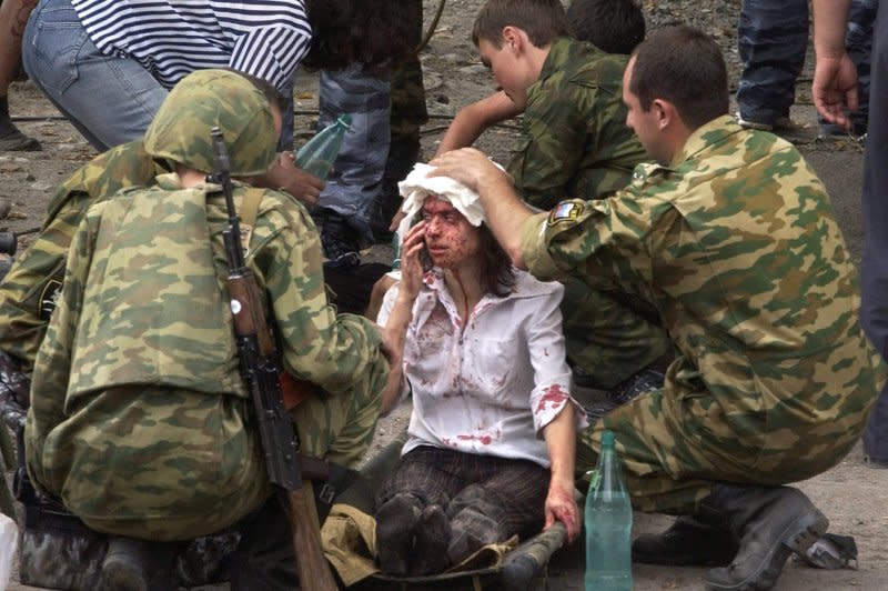Russian soldiers give first aid to a former hostage after special forces enter her school in Beslan, North Ossetia, Russia, on September 3, 2014, after a two-day hostage crisis. On September 1, 2004, a group of Chechen separatists took more than 1,000 people hostage at a the school. File Photo by STR/EPA