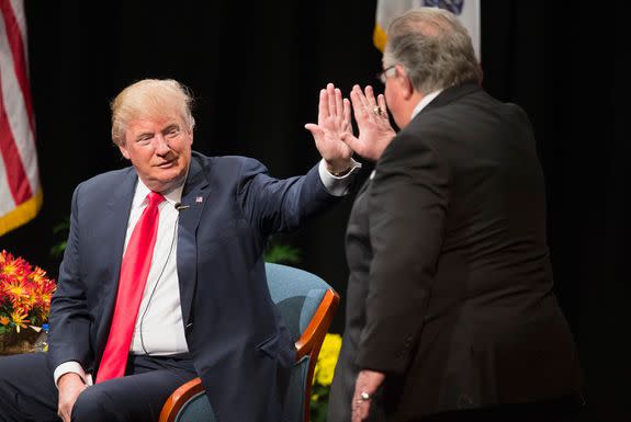 Donald Trump , then a presidential candidate, greets then-campaign co-chair Sam Clovis during a 2015 stop in Iowa.