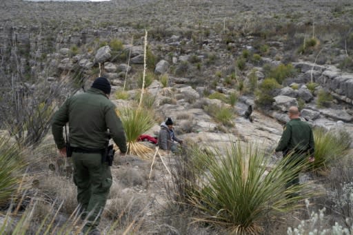 Border patrol agents Arain Carrera and Thaddeus Cleveland approach an injured Guatemalan migrant in a remote canyon of west Texas