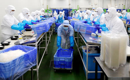 FILE PHOTO - Workers pack salads at a food factory in Narashino, Japan, April 17, 2018. REUTERS/Toru Hanai/File Photo