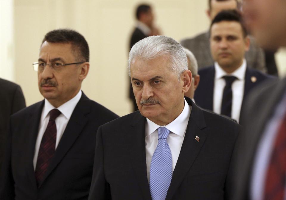 Turkey's Prime Minister Binali Yildirim, center right, arrives to speak to The Associated Press in Ankara, Turkey, Thursday, March 9, 2017. Turkish Prime Minister Binali Yildrim told reporters that Germany seems to be taking sides in the upcoming referendum, but he did not repeat the Nazi comparison. (AP Photo/Burhan Ozbilici)