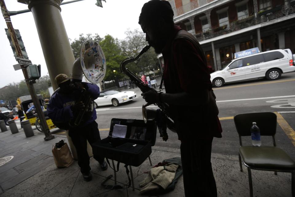 This Jan. 15, 2013 photo shows street musicians performing across the street from Jackson Square in New Orleans. Artists painting on canvas, clowns making balloon animals, street performers and jazz musicians are among the free entertainment to be found in Jackson Square, a one-block section of the French Quarter anchored by a lush green space with benches set among gardens and grand oak trees. (AP Photo/Gerald Herbert)