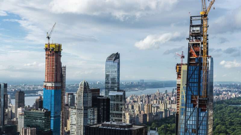 Skyscrapers under construction against the Manhattan skyline.