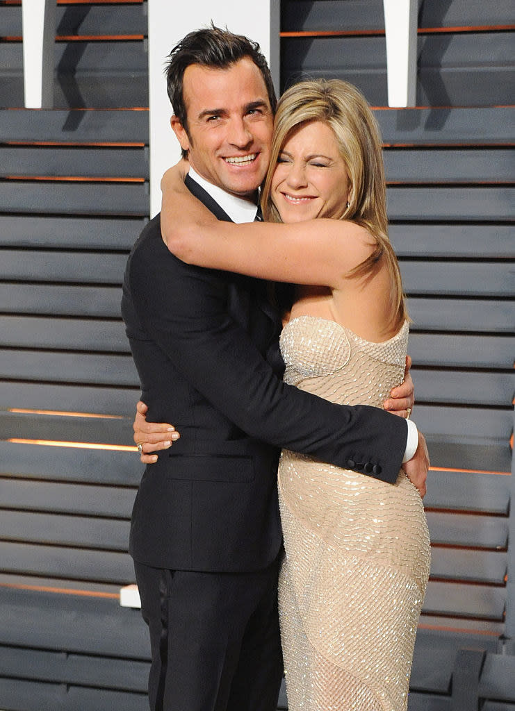 Justin Theroux (L) and Jennifer Aniston hugging at the 2015 Vanity Fair Oscar Party