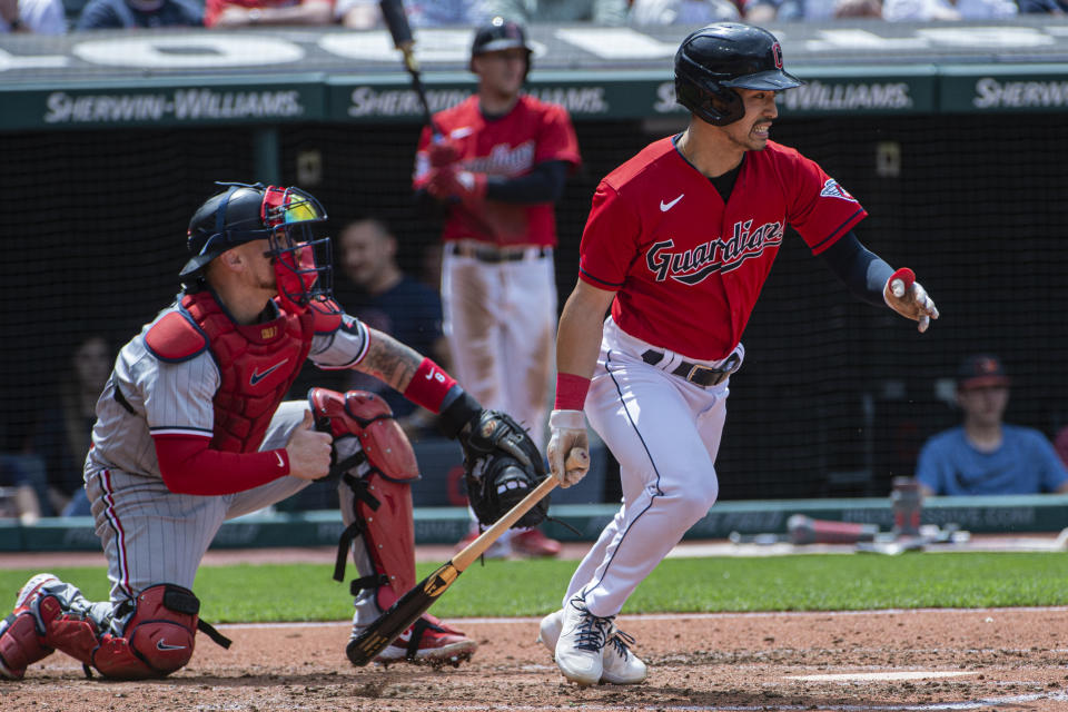 Cleveland Guardians' Steven Kwan, right, heads to first base and beats out an infield hit off Minnesota Twins starting pitcher Joe Ryan as Minnesota Twins' Christian Vazquez, left, watches during the fifth inning of a baseball game in Cleveland, Sunday, May 7, 2023. (AP Photo/Phil Long)