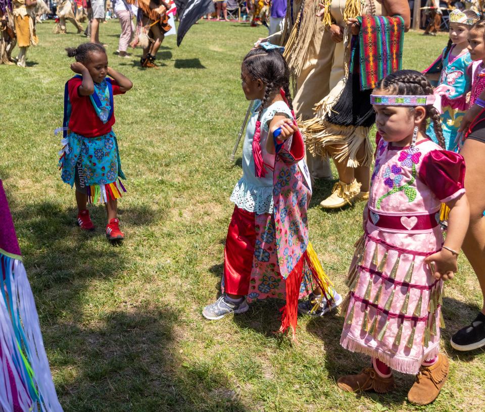 Je’Sire Mobley, 3, has his hands over his ears during the opening ceremony while his sibling Journē Mobley, 4, watches him at the Wampanoag Powwow Grounds in Mashpee on Friday. 
Sophie Proe/Cape Cod Times