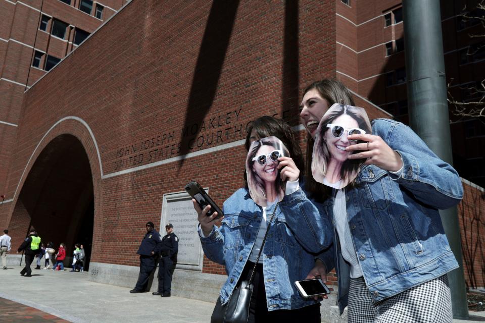 Two fans of actress Lori Loughlin hold cutout photos of her outside federal court in Boston where Loughlin is scheduled to face charges in a nationwide college admissions bribery scandal, on April 3, 2019.