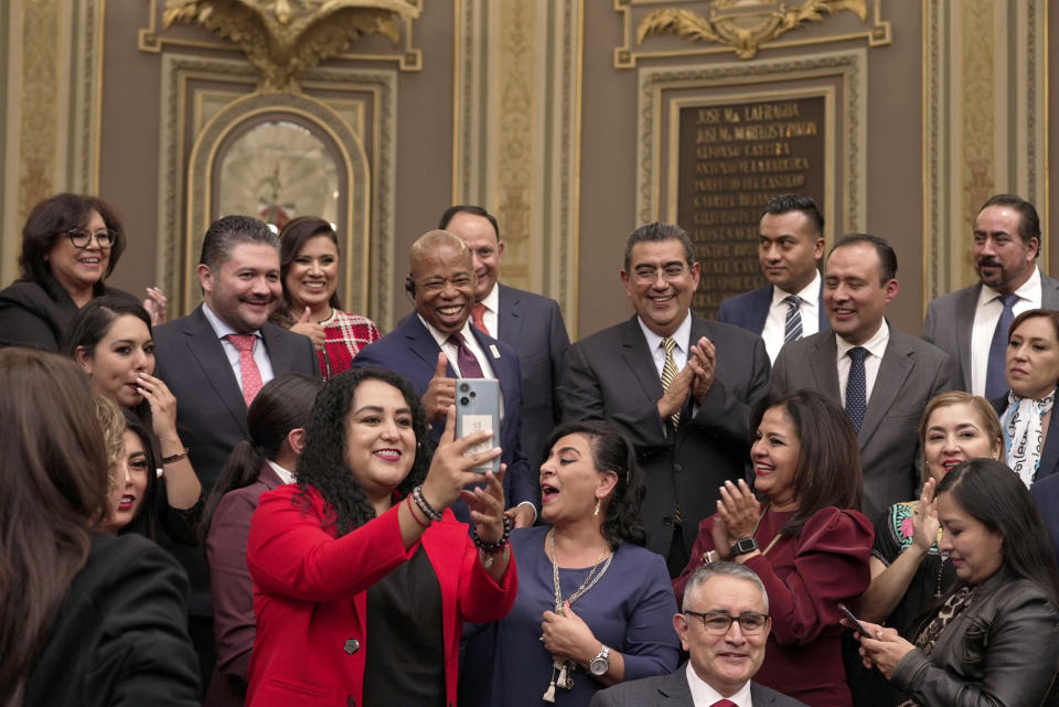 The Mayor of New York City Eric Adams, center, poses for photos with local lawmakers at the Puebla state congress in Mexico, Thursday, Oct. 5, 2023. Adams is visiting the city of Puebla, just outside the nation's capital, as part of a four-day trip to Latin America which he hopes will ease the burden of asylum seekers on New York. (AP Photo/Fernanda Pesce)