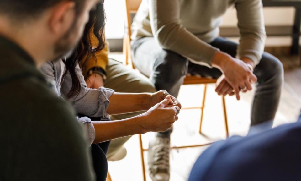 File photo of people anxiously fidgeting their hands while sharing stories during a group therapy session