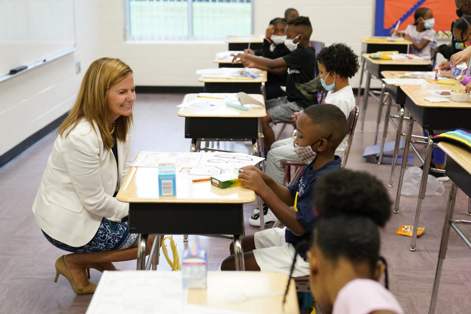 Henry County Board of Education Chair Holly Cobb, left, talks to students at Tussahaw Elementary school on Wednesday, Aug. 4, 2021, in McDonough, Ga. Schools have begun reopening in the U.S. with most states leaving it up to local schools to decide whether to require masks. (AP Photo/Brynn Anderson)