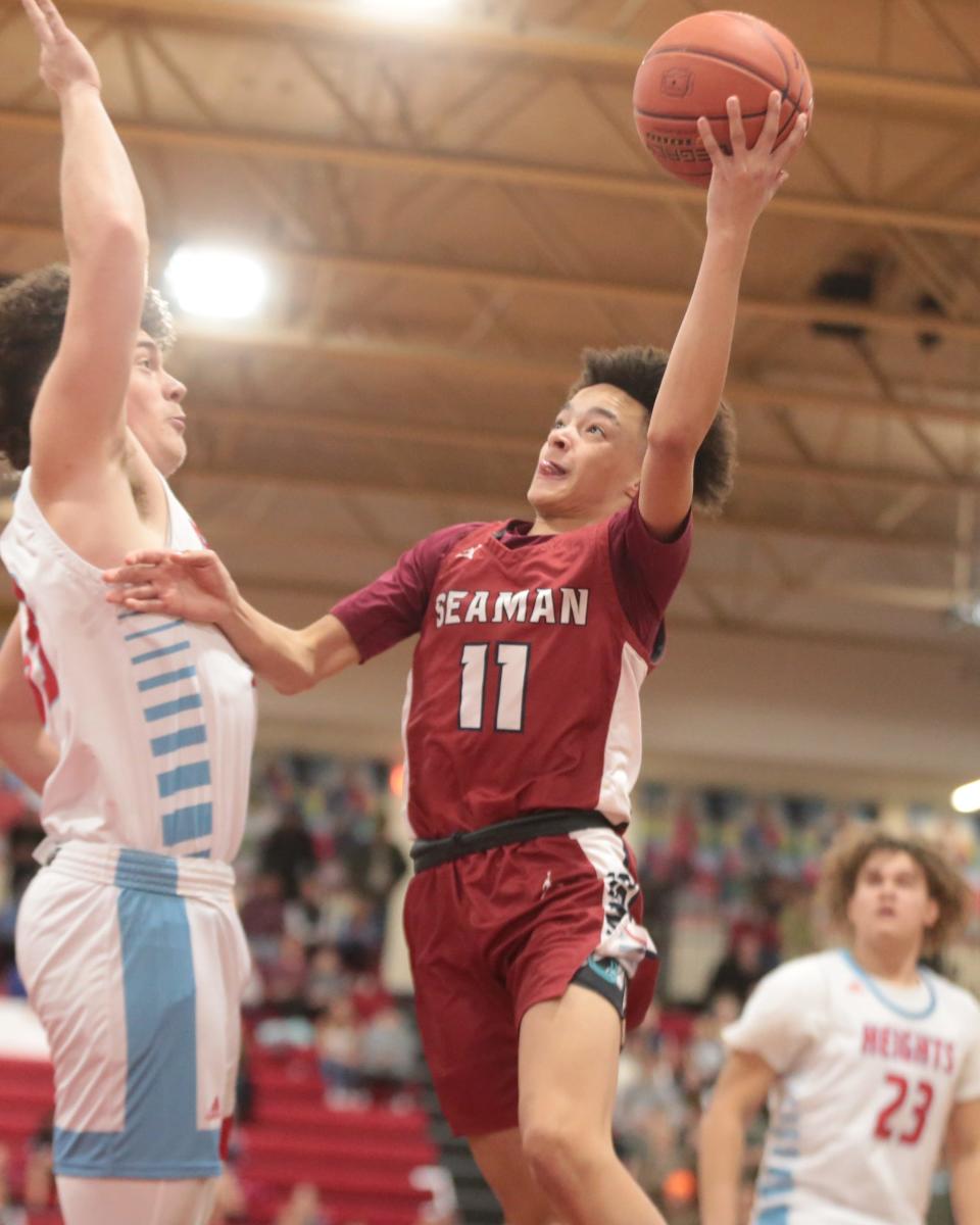 Seaman freshman KaeVon Bonner (11) jumps up for a layup against Shawnee Heights sophomore Deacon Pomeroy (33) during the first quarter of Friday's game.