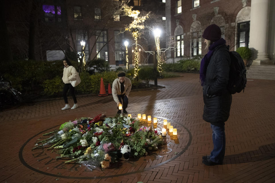 People pause and place a candle at a make-shift memorial for Tessa Majors inside the Barnard campus, Thursday, Dec. 12, 2019, in New York. Majors, a 18-year-old Barnard College freshman from Virginia, was fatally stabbed in a park near the school's campus in New York City. (AP Photo/Mary Altaffer)