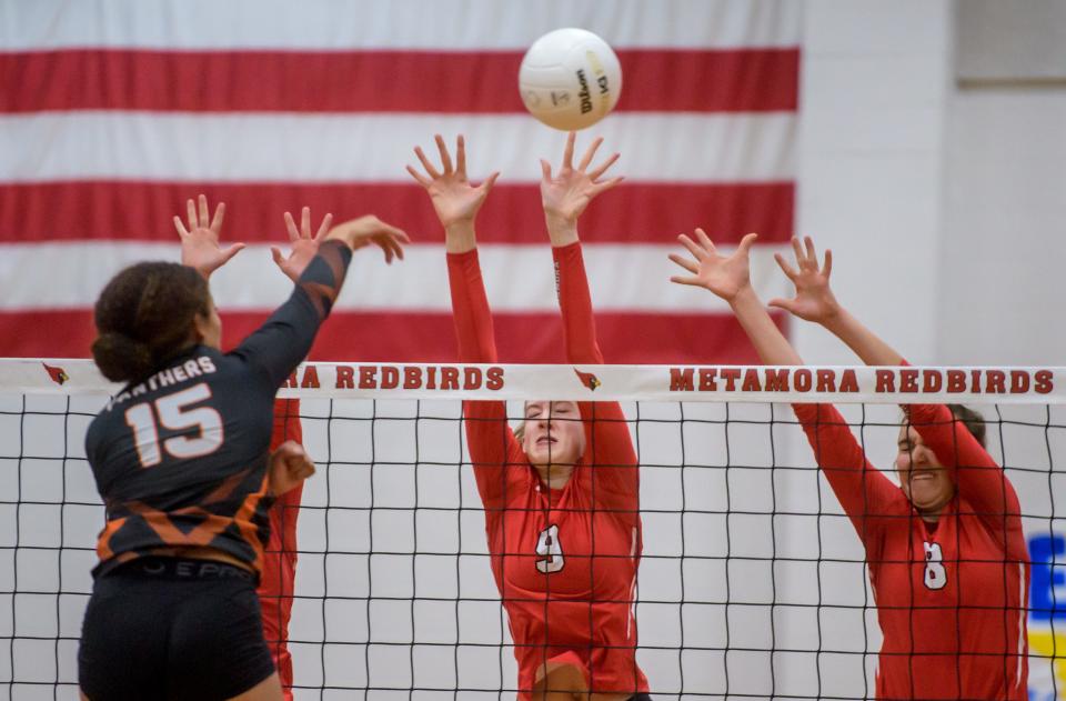 Washington's Teriana Jones (15) hits the ball past Metamora's Esma Frieden (8) and Sophie Fletcher during their Class 3A volleyball regional title game Thursday, Oct. 27, 2022 in Metamora. The Redbirds defeated the Panthers 25-12, 25-19.