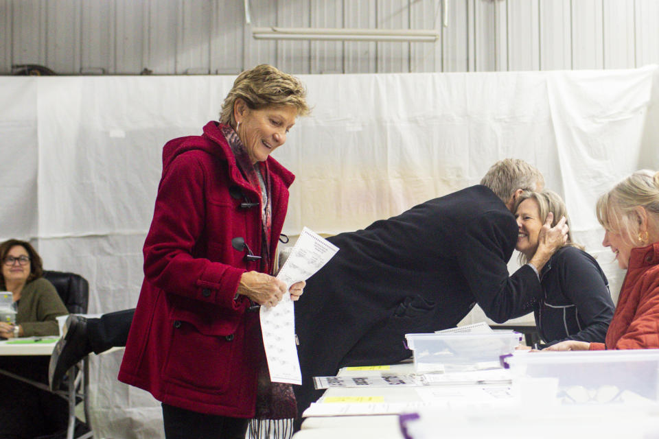 Republican gubernatorial candidate Scott Jensen greets a poll worker as he and his wife Mary Jensen checks in at Laketown Town Hall to cast their votes Tuesday, Nov. 8, 2022, in Chaska, Minn. (AP Photo/Nicole Neri)