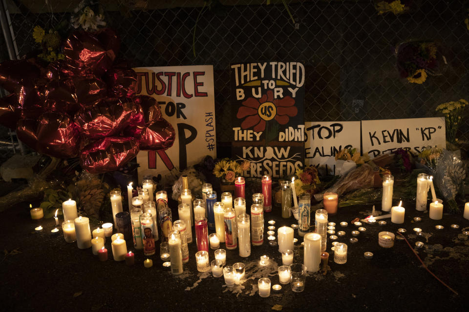 Candles and signs are seen at a memorial as people gather for Kevin Peterson Jr., who was killed in Thursday's shooting with police involved, at a candlelight vigil in Vancouver, Wash., Friday, Oct. 30, 2020. The Clark County Sheriff's office has not released any details on the Thursday evening shooting in Hazel Dell, but a man told The Oregonian/OregonLive that his 21-year-old son was fatally shot by police. (AP Photo/Paula Bronstein)