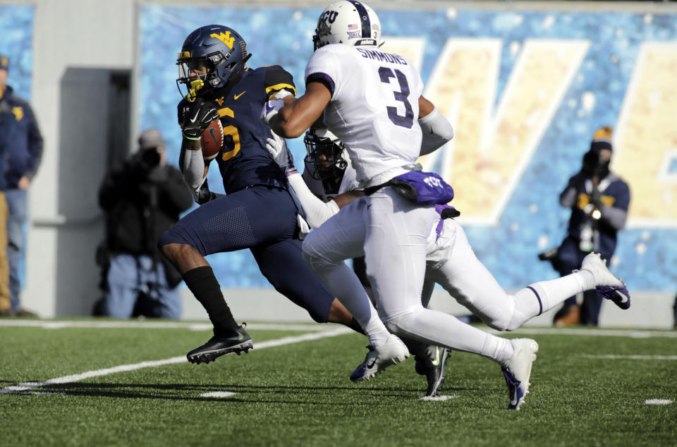 West Virginia running back Kennedy McKoy (6) runs for a touchdown while being chased by TCU cornerback Jeff Gladney (12) and safety Markell Simmons (3) during the first half of an NCAA college football game Saturday, Nov. 10, 2018, in Morgantown, W.Va. (AP Photo/Raymond Thompson)