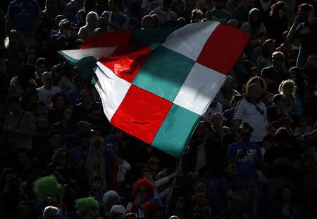 Italy's supporters wave a flag during the match against England in their Six Nations rugby union match at Olympic Stadium in Rome, March 15, 2014. REUTERS/Tony Gentile