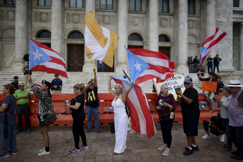 People join a protest organized by Puerto Rican singer Rene Perez of Calle 13 over emergency aid that until recently sat unused in a warehouse amid ongoing earthquakes, in San Juan, Puerto Rico, Thursday, Jan. 23, 2020. Protesters demanded the ouster of Gov. Wanda Vázquez. (AP Photo/Carlos Giusti)