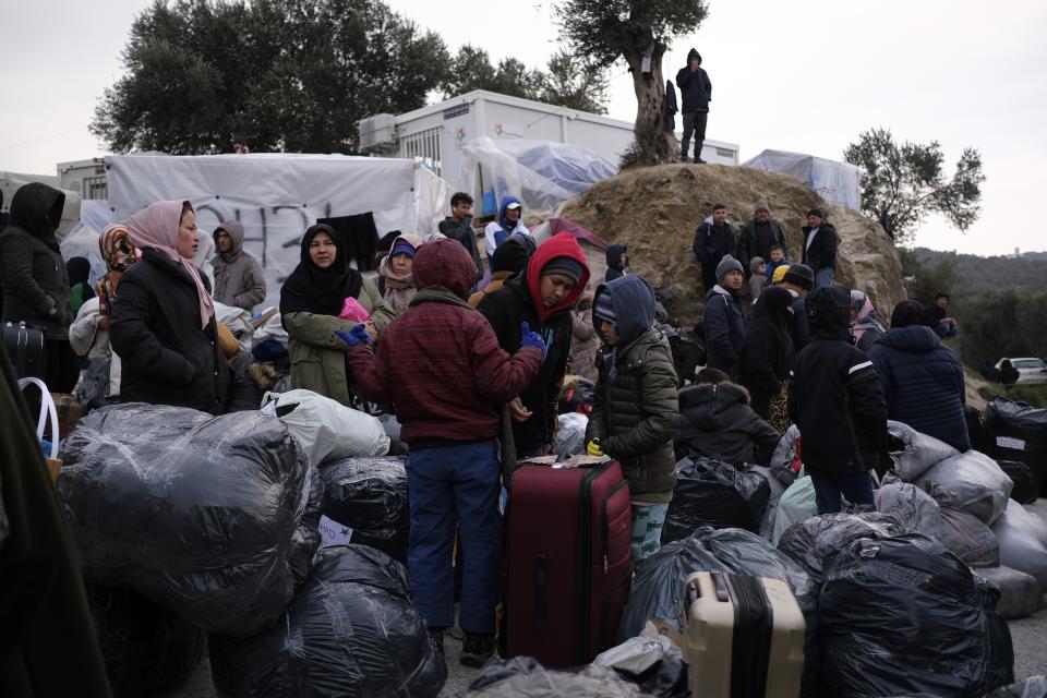 Refugees and migrants wait to leave from Moria refugee camp and go to the mainland Greece, on the northeastern Aegean island of Lesbos, Greece, on Tuesday, Jan. 21, 2020. Some businesses and public services on the island are holding a 24-hour strike on Wednesday to protest the migration situation where thousands of migrants and refugees are stranded in overcrowded camps in increasingly precarious conditions. (AP Photo/Aggelos Barai)